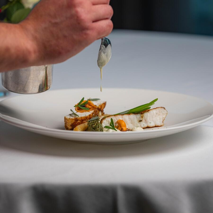 Chef menyelesaikan plating dengan saus