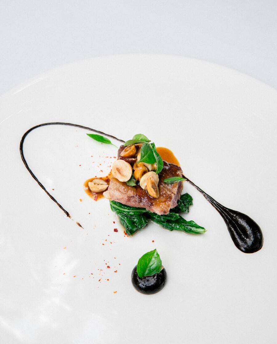 Plating hidangan utama dengan garnish rempah di piring putih