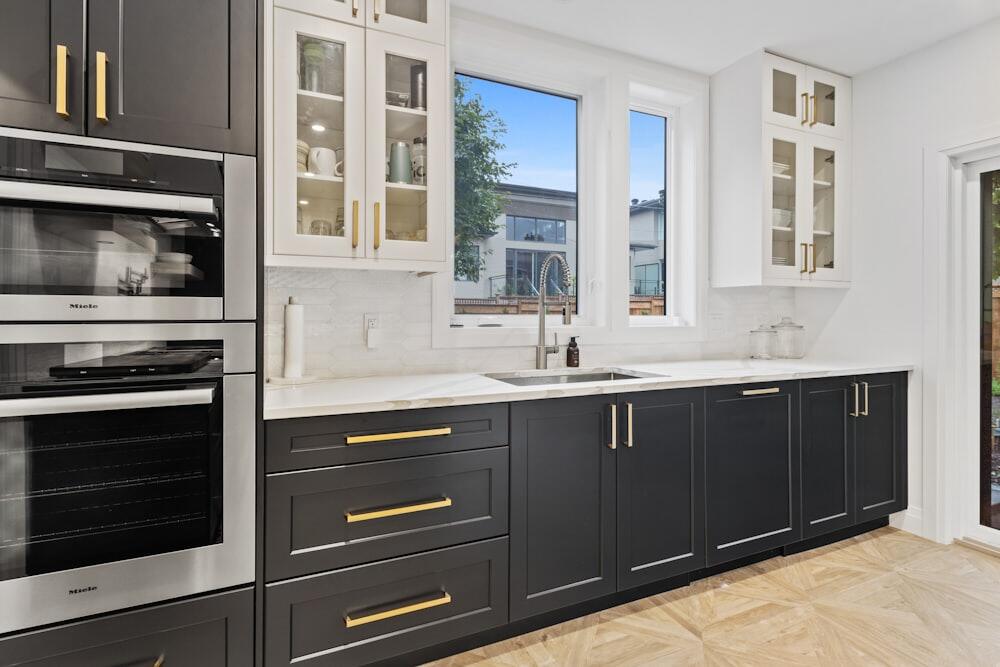 Dapur lurus gelap dengan handel kuningan dan meja engineered stone