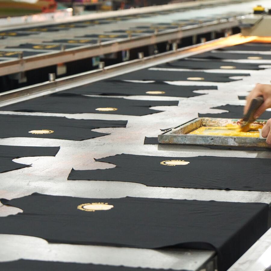 Proses potong dan sablon bahan di meja produksi